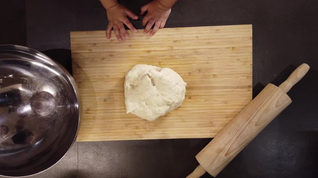 father and daughter put the pizza dough in an oiled bowl to let it rise