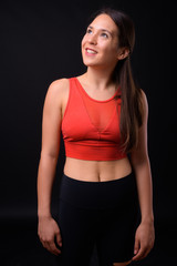 Young multi ethnic beautiful woman ready for gym against black background