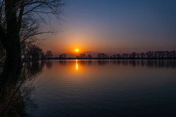 Colorful sunset with clear sky at lake coast. Relax landscape