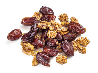 Mixture of dried dates and peeled walnut halves on a white background