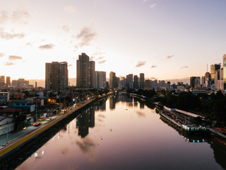 Pasig River in Metro Manila leading towards the Makati City Skyline while sunrise