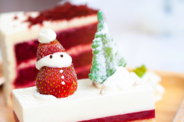 Red Christmas cake, decorate the cake with Christmas trees from sugar and snowman with strawberry and white cream.