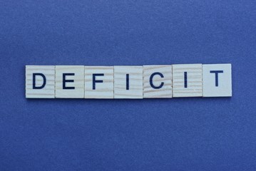 the text of the gray word deficit of small wooden letters on a black background