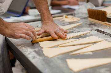 The process of making croissants in a bakery.