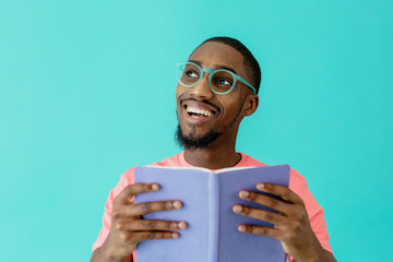 Portrait of a happy  young person reading with glasses holding book and looking up, isolated on...