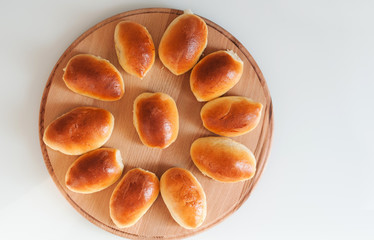 homemade patties pirozhki on round wooden board