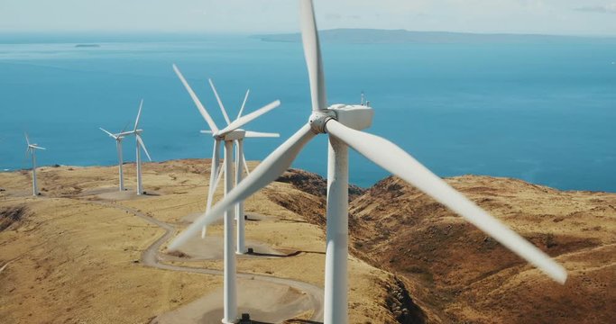 Cinematic aerial view of large wind turbines producing clean sustainable energy, clean energy future