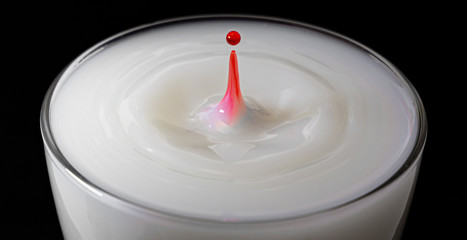 Detalle gota roja sobre leche