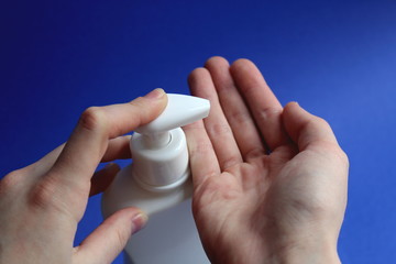 Female hands squeeze disinfectant liquid from a bottle