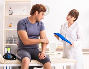 Obraz premium Young male patient visiting female doctor traumatologist