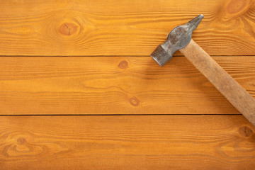 Iron hammer with wooden handle on wooden background, free space for text, top view