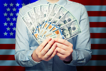 Hands holding cash money us dollars banknote on American flag background