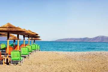 Palm parasols with empty chairs, beautiful beach