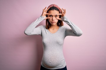 Young beautiful teenager girl pregnant expecting baby over isolated pink background Trying to open eyes with fingers, sleepy and tired for morning fatigue