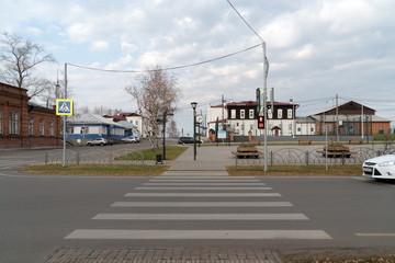 Fototapeta na wymiar A pedestrian crossing over the roadway leads to the central square with historic buildings. Yeniseisk. Krasnoyarsk region. Russia.