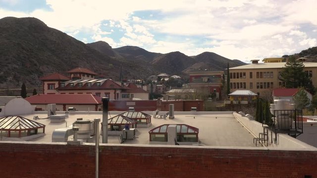 Rising over the rooftops of homes in Bisbee, Arizona - aerial ascend