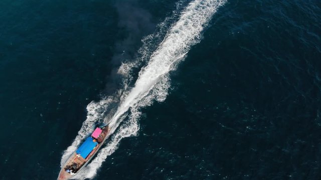 Motor Boat Sailing And Leaving A Wake Near The Shore In The Emerald Blue Lake In Khao Sok National Park, Thailand.- aerial shot