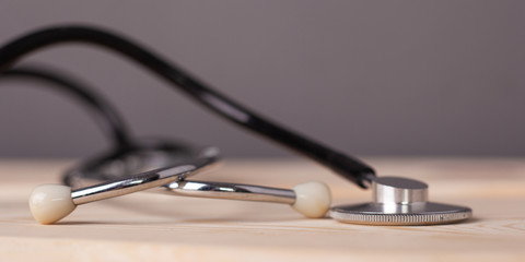 medical stethoscope on wooden table close-up