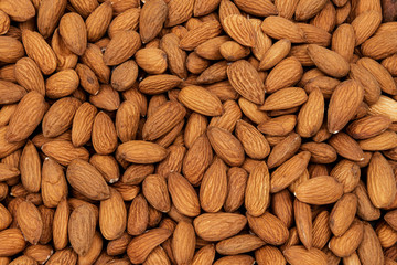 Heap of raw almond nuts as a background
