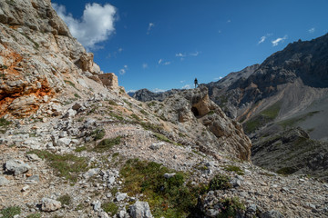 Tourist crossing the via ferrata trail with equipment in the dolomites