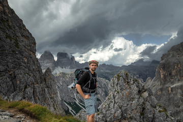 The man in a hat with his back on the background of the panorama in the Dolomites