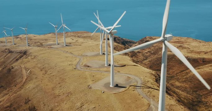 Cinematic aerial view of large wind turbines producing clean sustainable energy, clean energy future