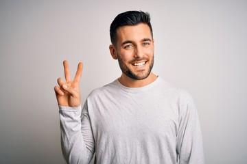 Young handsome man wearing casual t-shirt standing over isolated white background smiling with...