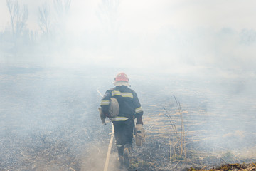 Firefighters battle a wildfire. firefighters spray water to wildfire. Australia bushfires, The fire is fueled by wind and heat.