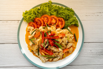 Stir-fried squid with salted egg yolk, onion, spring onion and Chili pepper on white plate. Food concept. Thailand seafood cuisine. thai food