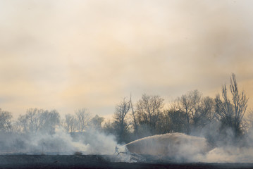 Firefighters battle a wildfire. firefighters spray water to wildfire. Australia bushfires, The fire is fueled by wind and heat.