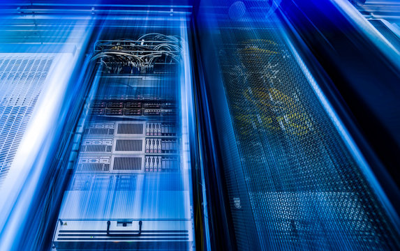 Racks with powerful servers are in the data center. The computer equipment of Internet provider is in the server room. blur in motion as visualization of processing speed. View from the bottom