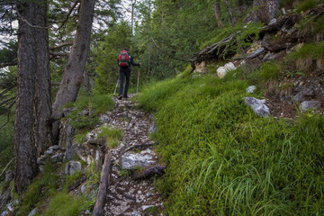 Fototapeta na wymiar Tourist's crossing along the path leading to the via ferrata trail in the Dolomites
