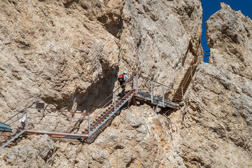 Tourist climbing steel stairs fixed to the rock
