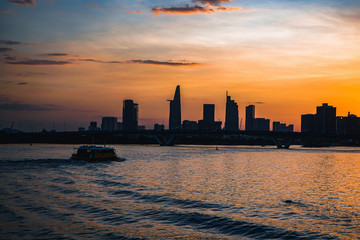 River city view landscape at twilight sunset. Boat on river with tranquil water. Hochiminh city Saigon vietnam cityscape building with Bitexco tower