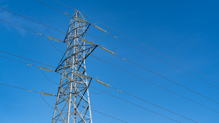 Electricity pylon in the UK shot  against a blue sky
