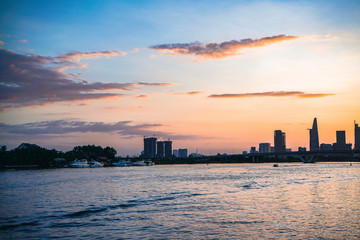 River city view landscape at twilight sunset. Boat on river with tranquil water. Hochiminh city Saigon vietnam cityscape building with Bitexco tower