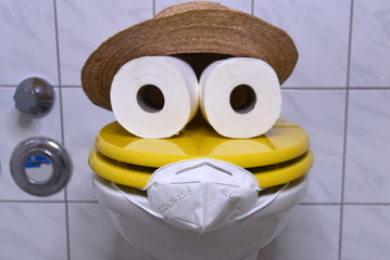 Klopapier mit Hut und Mundschutz auf einem gelben Toilettendeckel