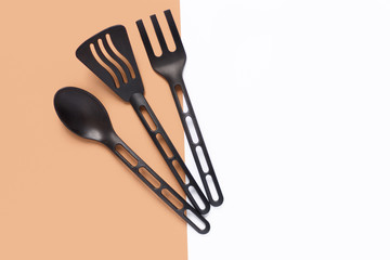the kitchen composition. black appliances for cooking. fork spoon and spatula on a white and brown background