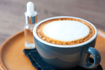 Hot cappuccino coffee with white cream foam serve in coffee cup set, lay on wooden round tray, classice coffee drink.