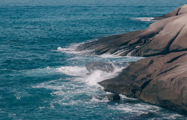 Ocean waves crash against stone shores