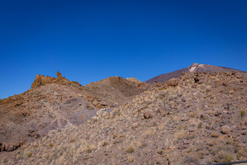 Fototapeta na wymiar Volcanic rocks in the hills of Tenerife with clear blue skies