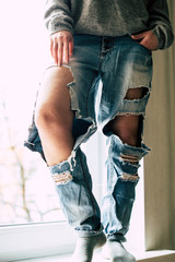 Girl and torn jeans. Modern youth