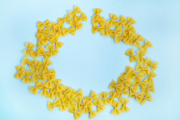 Frame of pasta bows on a gently blue background. Flat lay. Copy space