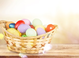 Colored easter eggs in the basket on the desk