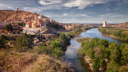 Fototapeta na wymiar Landscape the town of Asco with its nuclear power plant in the background and the Ebro river that cools it, Tarragona, Spain
