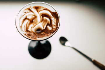 Glass of chocolate dessert on a white windowsill