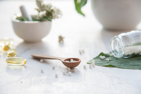 homeopathic granules, medicinal herbs on a natural wooden table on a natural background. alternative medicine and homeopathy