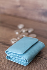 Blue wallet on a wooden background. Wallet and coins.