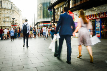 Motion blurred people shoppers on busy street