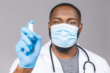 African american doctor man in gown face mask gloves isolated on grey background. Epidemic pandemic...